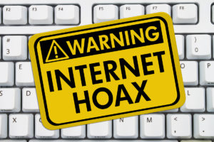 Warning of Internet Hoax Sign on Keyboard